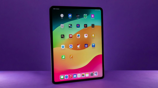 An iPad Pro standing against a purple background.