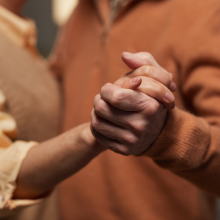 senior couple dancing while holding hands 