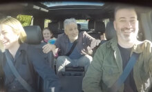 A group of people sit in a car, laughing.