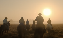 A herd of drovers ride into the sunset in a film still from "Territory".