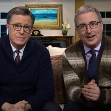 Stephen Colbert and John Oliver sit on a couch