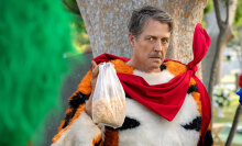 A man in a tiger costume looks angry while holding up a bag of cereal.