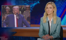 A woman sits at a talk show desk. In the top-left is an image of a man standing at a podium in front of a crowd.