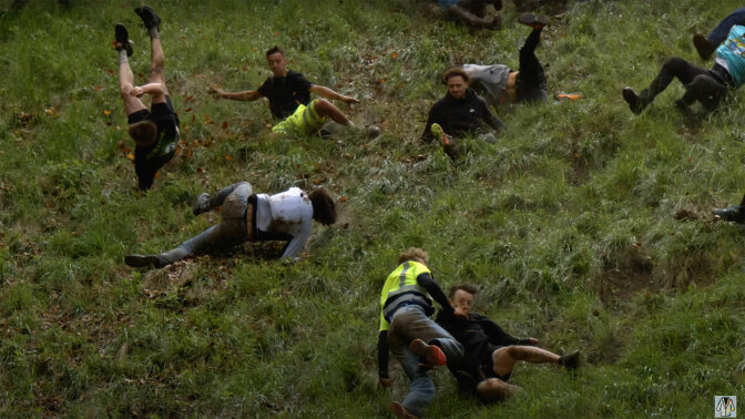 People falling down a steep hill are frozen in various stages of tumbling over.