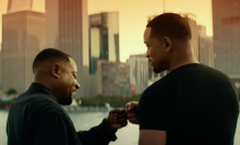 Martin Lawrence and Will Smith bump fists by the water.