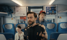 Kieran Culkin and Jesse Eisenberg walk through a train in Poland in the film "A Real Pain."