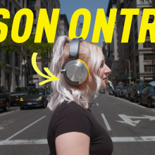 a woman crossing a busy street wearing the Dyson Ontrac headphones