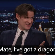 A man sits in a talk show chair, pointing and grinning. The caption at the bottom reads, "Mate, I've got a dragon."