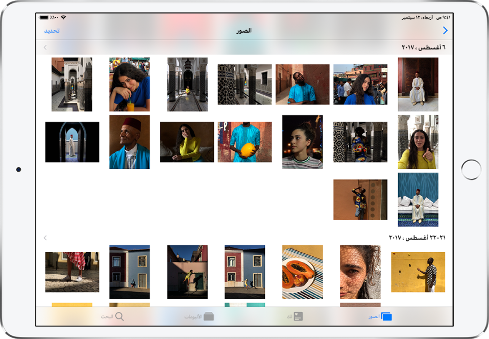 تطبيق الصور في العرض الأفقي. في أسفل الشاشة من اليمين إلى اليسار، تظهر علامات تبويب الصور ولك والألبومات والبحث. علامة تبويب الصور محددة، والشاشة أعلاها تعرض شبكة من الصور المصغرة للصور منظمة في مجموعات حسب اللحظة. فوق كل لحظة يظهر تاريخ التقاط الصور. يمكن الضغط على التاريخ لعرض تفاصيل حول اللحظة. ويمكن الضغط على صورة مصغرة لصورة لعرض الصورة في وضع ملء الشاشة.