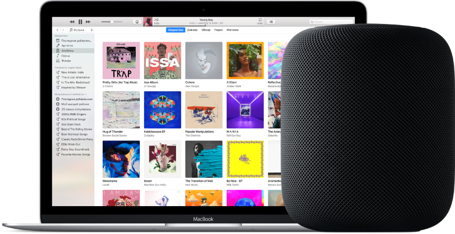 MacBook с iTunes на экране, рядом стоит HomePod.