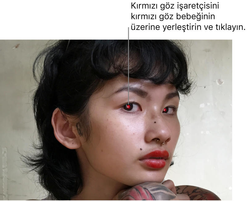 Kırmızı göz bebekleri görünen bir kişinin fotoğrafı.