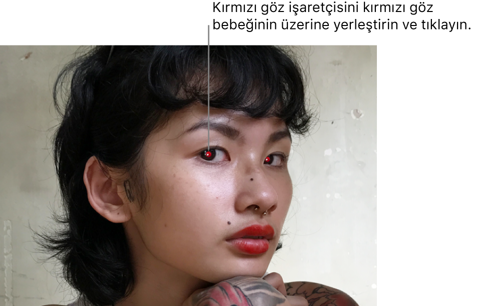 Kırmızı göz bebekleri görünen bir kişinin fotoğrafı.