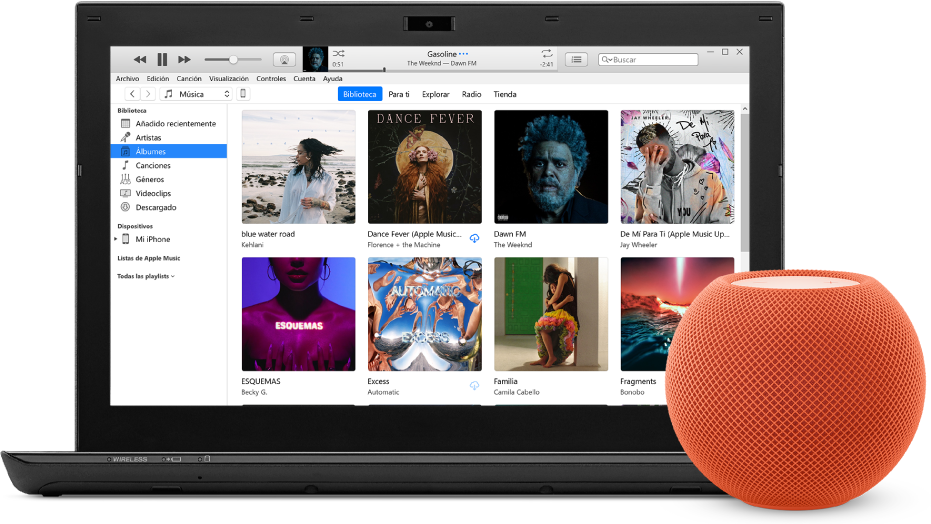 Un PC con iTunes en la pantalla y un HomePod mini cerca.