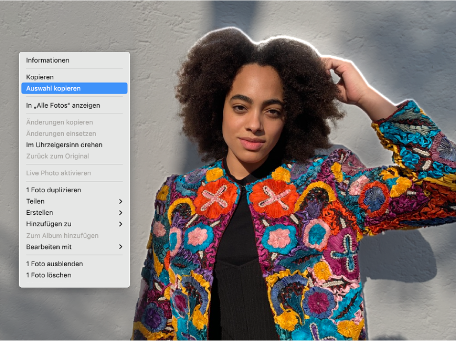 Um die Person im Vordergrund eines Fotos wird eine Umrisslinie angezeigt. Außerdem erscheint ein Menü, in dem „Auswahl kopieren“ ausgewählt ist.