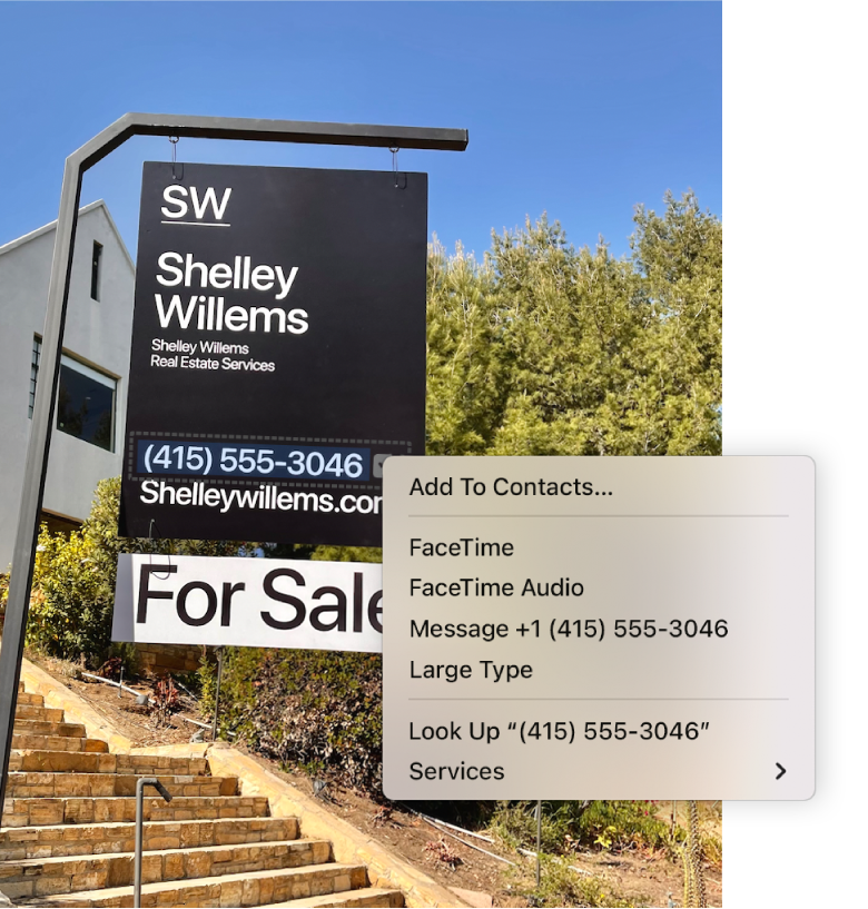 A photo of a Real Estate For Sale sign showing the agent’s phone number selected as Live Text and a menu presenting options to add the phone number to Contacts, call the number, start a FaceTime call, send a text message and more.