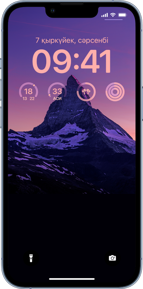 Жекелендірілген iPhone құлыптау экраны, фотосурет фонда тұр, ал температура, ауа сапасының көрсеткіші, AirPods батарея деңгейі және фитнес сақиналары үшін экранның жоғарғы жағында виджеттер бар.