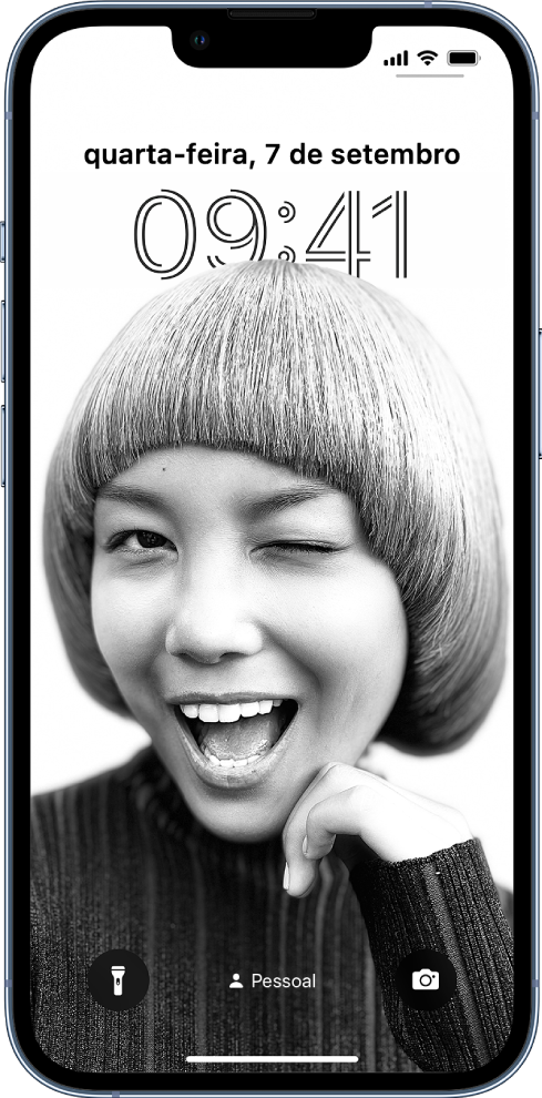 O ecrã bloqueado a mostrar uma fotografia de fundo personalizada e uma hora e data personalizada. Na parte inferior do ecrã encontram-se, da esquerda para a direita, o botão da lanterna, o modo de concentração “Tempo pessoal” ativado e o botão da câmara.