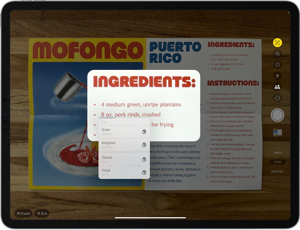 Het Camera-scherm met een recept in het camerakader. Tekst in het menu is geselecteerd en onderstreepte tekst toont omrekenopties voor 8 ounce. Onder in het scherm staan knoppen voor snelle taken om 2 cups en 8 ounce om te rekenen.