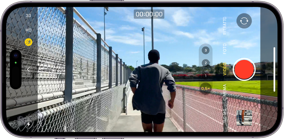iPhone è in orientamento orizzontale. La fotocamera è aperta in modalità Video. I pulsanti per il flash e per la modalità Azione sono visibili nell’angolo in basso a sinistra dello schermo. La modalità Azione è attivata. Il pulsante dei controlli della fotocamera è a sinistra dello schermo, al centro rispetto agli altri elementi, mentre nell’angolo in alto a destra sono presenti degli interruttori rapidi per modificare risoluzione video e frequenza dei fotogrammi. Sul lato destro, dall’alto verso il basso, sono presenti il pulsante “Strumento di selezione della fotocamera - posteriore”, il pulsante di registrazione e il pulsante per visualizzare foto e video nella libreria. L’inquadratura mostra una persona che corre.