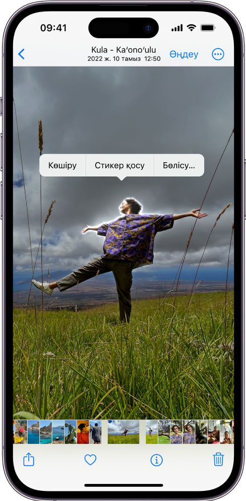 «Фотолар» қолданбасы адамның фотосымен ашық. Адам таңдалған және «Стикер қосу» опциясы жоғарыдағы мәзірде қолжетімді.