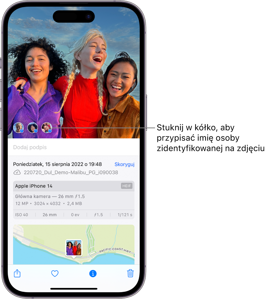 Górna część ekranu iPhone’a z wyświetlonym zdjęciem otwartym w aplikacji Zdjęcia. W lewym dolnym rogu zdjęcia, obok osób widocznych na nim wyświetlane są znaki zapytania.