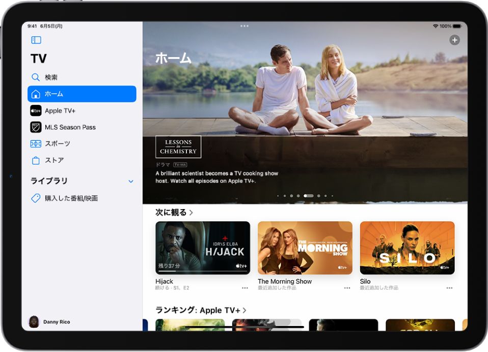 Apple TV+の画面。「次に観る」と「トップチャート」の上の中央に、注目のApple Originalが表示されています。Apple TV+の行。左側には上から順に、「検索」、「ホーム」、「Apple TV+」、「MLS Season Pass」、「スポーツ」、および「ストア」タブがあります。