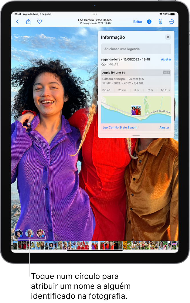 O ecrã do iPad mostra uma fotografia aberta na aplicação Fotografias. No canto inferior esquerdo do ecrã da fotografia aparecem pontos de interrogação junto às pessoas que aparecem na fotografia.