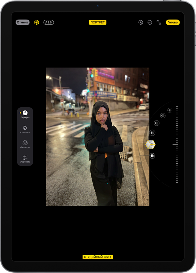 Экран редактирования фото в режиме «Портрет». По центру экрана показана фотография, справа от нее расположены варианты эффектов портретного освещения. Выбрана кнопка «Студийный свет», рядом расположен бегунок для настройки интенсивности эффекта. В левой части экрана находятся кнопки «Портрет», «Изменить», «Фильтры» и «Обрезать». Выбрана кнопка «Портрет».