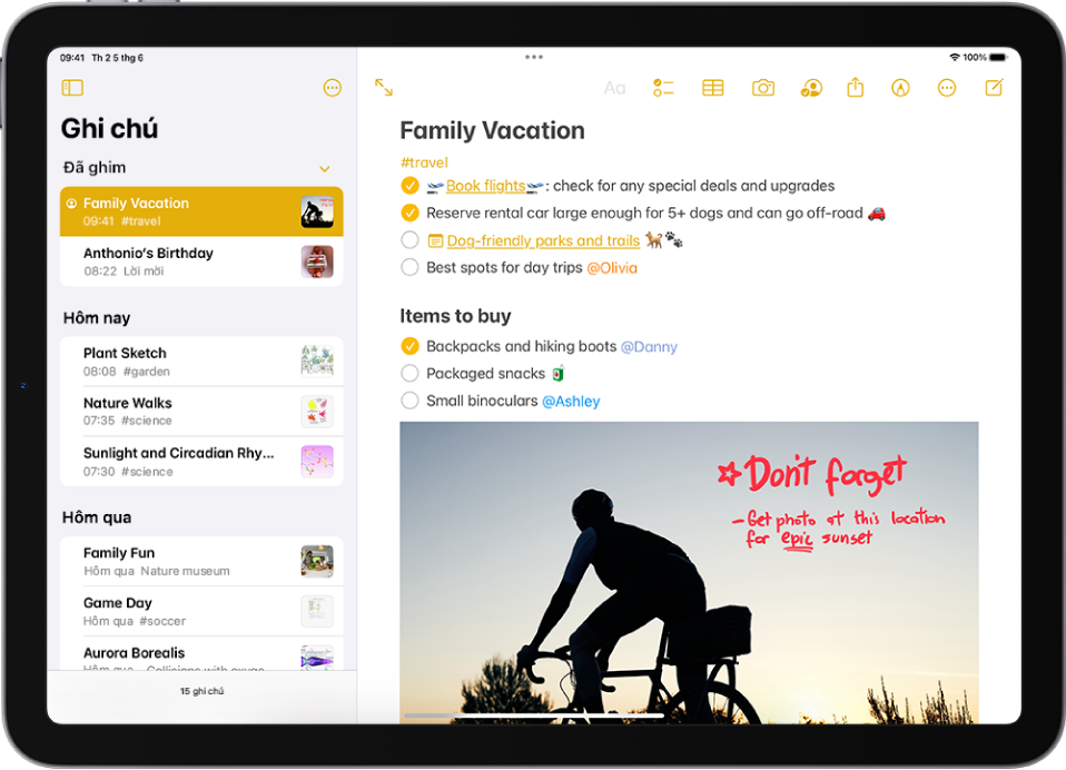iPad ở hướng ngang với ứng dụng Ghi chú được mở. Thanh bên hiển thị một danh sách các ghi chú với các nút ở trên cùng để ẩn thanh bên và quản lý thư mục. Ghi chú được chọn trong thanh bên được mở ở bên phải và hiển thị một danh sách nhắc việc cho một kỳ nghỉ gia đình. Phía trên ghi chú là các nút để xem ghi chú ở chế độ toàn màn hình, định dạng văn bản, thêm danh sách kiểm tra, thêm bảng, thêm ảnh, chia sẻ ghi chú, hiển thị công cụ viết tay, quản lý ghi chú và tạo một ghi chú mới.