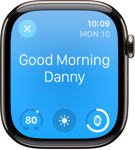 Apple Watch, показващ екрана за събуждане. В горния край се появяват думите Good Morning (Добро утро). Отдолу са температурата, атмосферните условия и зарядът на батерията.