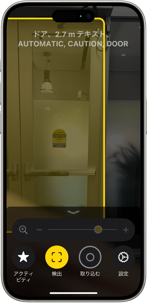 拡大鏡アプリが開いていて、ドアの検出が進行中です。説明には、ドアまでの距離と、ドアに書かれているテキストの内容が示されています。