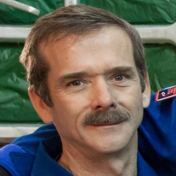 BAIKONUR, KAZAKHSTAN - DECEMBER 14:  In this handout image provided by NASA, (L-R) Expedition 34/35 Flight Engineer Chris Hadfield of the Canadian Space Agency, Soyuz Commander Roman Romanenko and Flight Engineer Tom Marshburn of NASA pose in front of the Soyuz TMA-07M spacecraft at the completion of the final dress rehearsal for their launch, at the Integration Facility at the Baikonur Cosmodrome on December 14, 2012 on Baikonur, Kazakhstan. Launch of the Soyuz rocket is scheduled for December 19 and will send the astronauts on a five-month mission aboard the International Space Station.  (Photo by Victor Zelentsov/NASA via Getty Images)