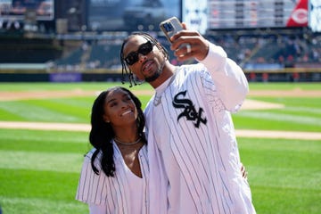 simone biles embracing husband jonathan owens and smiling as he holds his phone out for a selfie