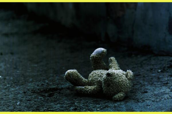 Against a gloomy background we see an abandoned teddy-bear, insinuating the absence of a child.  