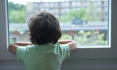 Lonely little boy looking out of the window