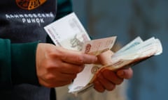 A shopper holds a sheaf of roubles at the Danilovsky market