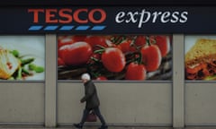 A woman passes a Tesco Express