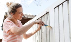 Woman paints fence