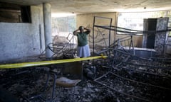 Rose-Marie Louis, a staff worker at the Orphanage of the Church of Bible Understanding, holds her head in disbelief amid the charred children’s home, including the unrecognizable body of a child marked by a yellow piece of paper, bottom right, in Kenscoff, on the outskirts of Port-au-Prince, Haiti, Friday, Feb. 14, 2020. A fire swept through this orphanage run by a Pennsylvania-based nonprofit group, killing over a dozen children, according to health care workers. (AP Photo/Dieu Nalio Chery)