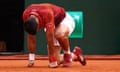 Novak Djokovic kneels down