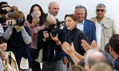 Phoebe Philo is surrounded by people clapping and taking photos