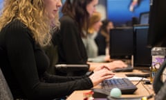 Two office workers at keyboards.