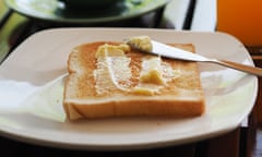 Buttered bread on white plate.