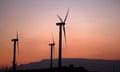 Wind turbines silhouetted against sunset.