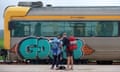 Backpackers standing in front of a train at a railway station<br>PWB3RF Backpackers standing in front of a train at a railway station
