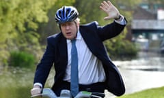 Boris Johnson waves as he rides a bike ride along the towpath of the Stourbridge canal in the West Midlands