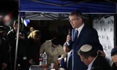 Yoav Kisch speaks into a microphone next to a gazebo