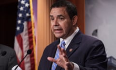 A man in a suit and tie in front of a US flag.