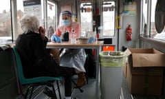 A healthcare worker helps a woman to take her swab sample, at a minibus that was converted into a Covid-19 mobile test centre in Walsall, England.