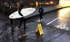 Tens of thousands watch puddle on Periscope<br>A person carrying a surfboard crosses the puddle outside Drummond Central in Newcastle upon Tyne, which became an internet sensation with tens of thousands of people watching it on Periscope. PRESS ASSOCIATION Photo. Picture date: Wednesday January 6, 2016. See PA story SOCIAL Puddle. Photo credit should read: Tom White/PA Wire